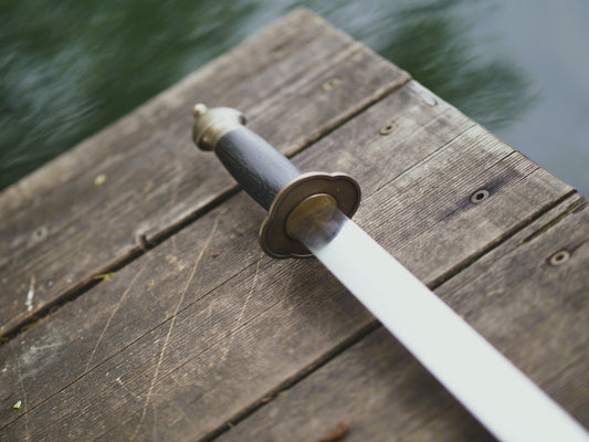 Sword on a wooden surface with water in the background