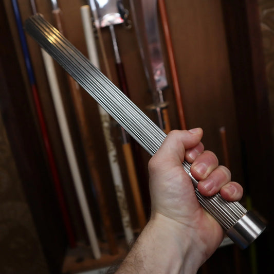 Hand holding heavy metal massage brush